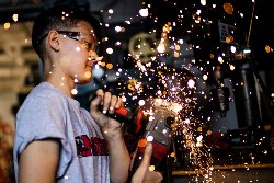 Image of student welding with sparks flying